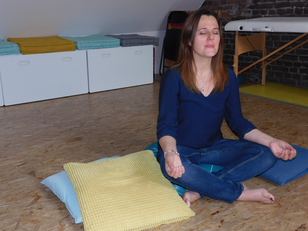 Fanny Caufriez de Courant Indigo est assise sur un coussin de méditation, mains sur les genoux, yeux fermés !