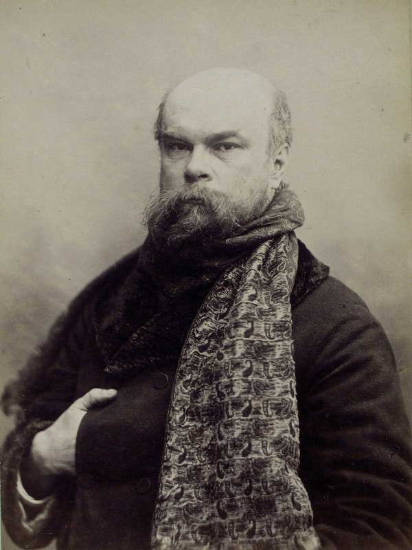 Portrait photographique d'Otto Wegener en noir et blanc de Paul Verlaine âgé, portant une écharpe à motifs et un manteau sombre